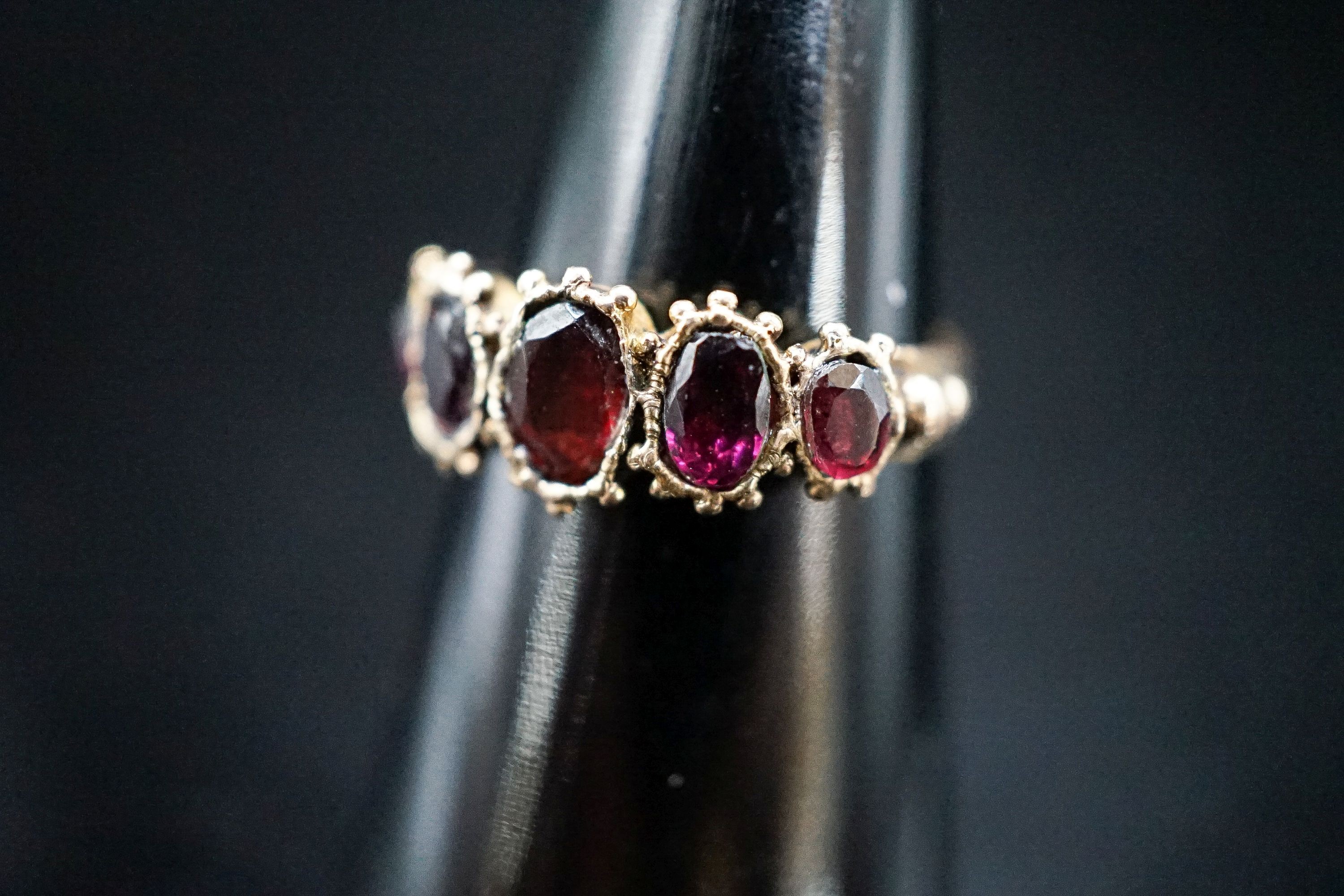 A 19th century yellow metal and graduated five stone garnet half hoop ring, size K, gross 2,.1 grams.